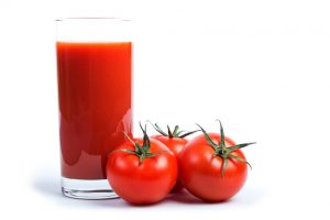 Tasty tomato juice and tomatoes over white.